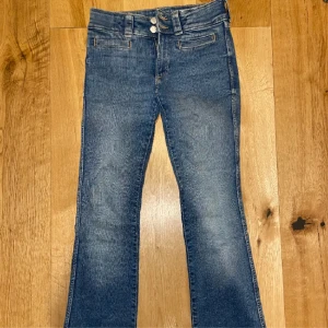 Blå lågmidjade butcut jeans - Blåa lågmidjade utsvängda jeans från H&M! Jätte snygga fickor där bak och fram. Har band så man kan justera storleken i midjan. Jätte trendiga och snygga! Storlek 164 men passar som S. Köparen står för frakten 