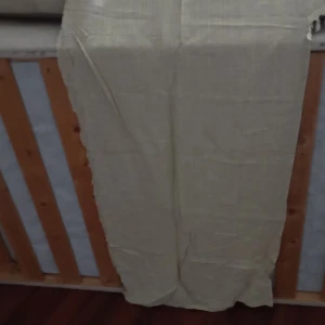 Gardin med Kappa tofsar  - Gardin med Kappa och tofsar beige i material Polyester .Passar till ett sovrum .