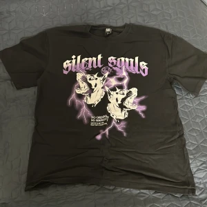 Graphic T-shirt - En clean svart graphictee med en riktigt fett färgglad design perfekt inför sommaren. Använt men i bra skick, 8/10. Storlek XL men sitter mer som en L eller oversized M. 