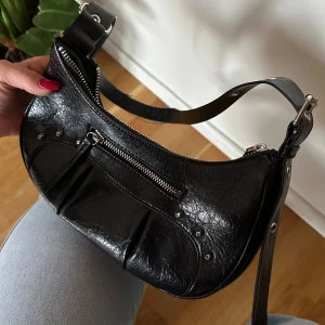 Snygg svart monki väska  - Supersnygg svart väska från monki! Sparaamt använd. Bandet är justerbart och går att göra ganska långt! Om flera bilder efterfrågas kan jag skicka!