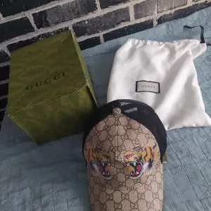 Gucci Tiger Keps med en dustbag och låda. Aldrig använt. Endast köp på Plick!!