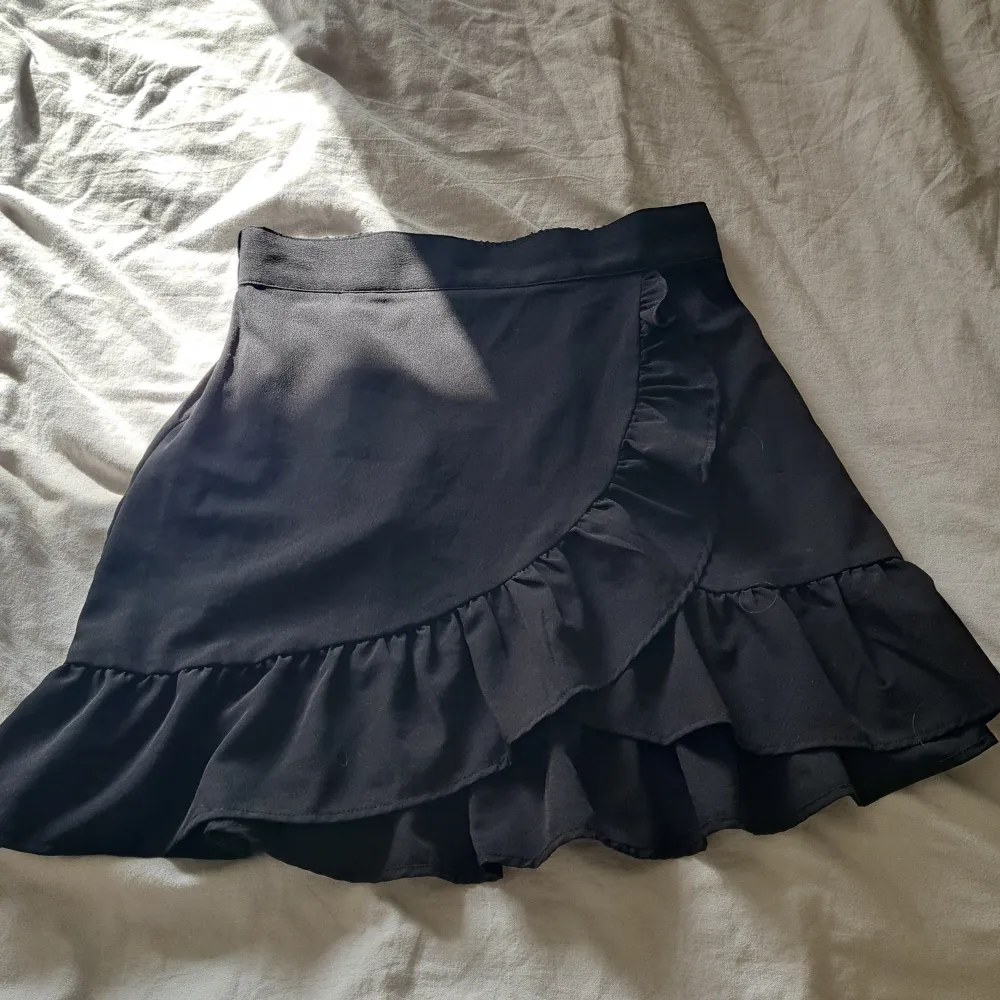 En fin svart kort kjol som passar jättebra nu till sommaren. Funkar nästan till allt. Storlek 146-152 men är stor i storleken. Kjolar.
