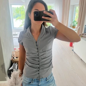 Grå topp - Grå topp med lite korsett liknande struktur. Tyget är glänsande så den ser lite glittrig ut. Bra skick!🙌🏻