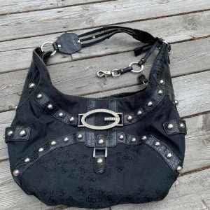 Guess axelremsväska i fint skick - Denna väskan är från GUESS är knappt andvänd och har inga skador original priset  är 2000kr