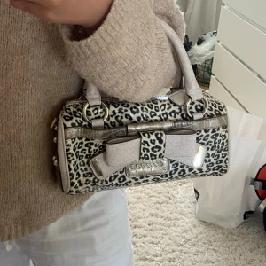 väska guess - supergullig liten väska i leopardmönster med rosettdetalj🎀 Har inga synliga skador, men ändå den här fina vintage känslan. Kommer med tillhörande guess-påse