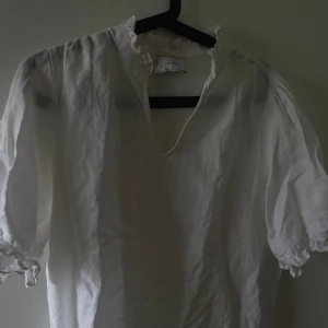 Topp/ blus från neo noir  - En vit topp/blus från neo noir i vit linne, använd ett fåtal gånger och mycket fint skick. Säljer gör 350kr då jag köpt den för 799kr.