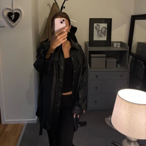 Svart läderkappa  - Säljer denna supersköna kappa i läder med band, säljer för att rensa garderoben