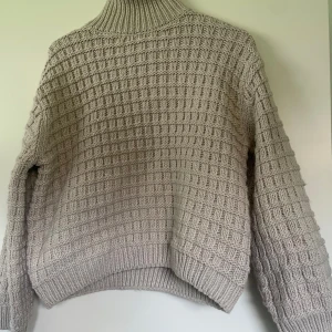 Stickad tröja - En superhärlig stickad tröja som inte sticks! Jättefin och mysig i en beige färg! Endast provad så helt i nyskick! 
