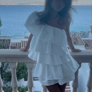 Vit volangklänning - Säljer min super fina skolavslutnings klänning från anielle. Endast använd 1 gång. Skriv för egna bilder💗