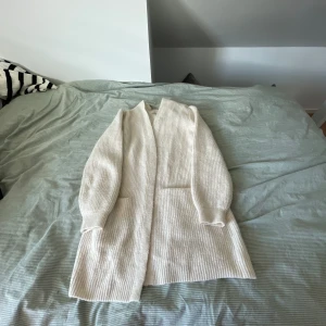 Lång stickad kofta❤️ - En lång stickad kofta, använd runt 10 ggr, lite nopprig här och där men ändå i bra skick, obs hund finns i hemmet 