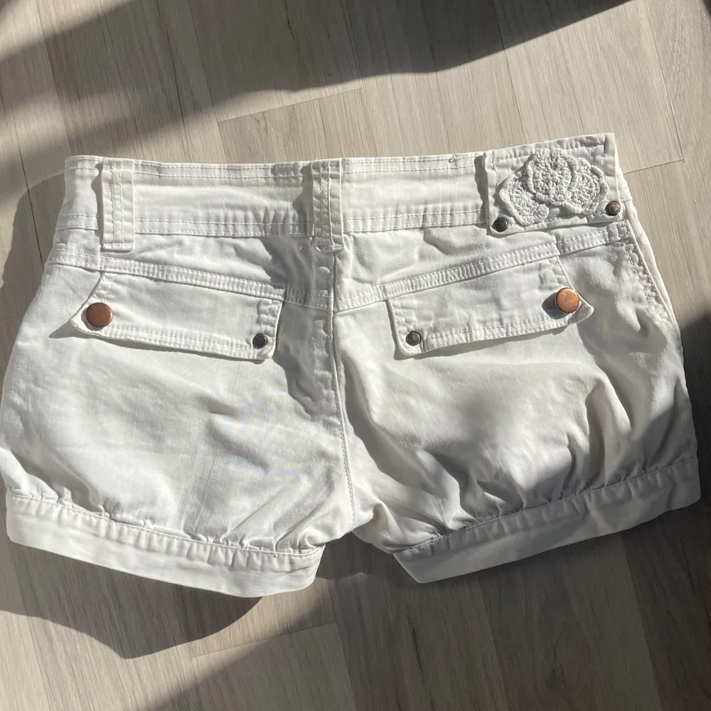 Så fina lågmidjade vita shorts. Söta fickor och detaljer! Unikt blommönster på bakdelen🌟 Superbra skick!. Shorts.