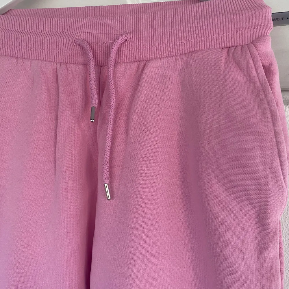 Mjukisbyxor i sweatshirt-material i rosa från NLY Trend (Nelly.com). En ”oversize” modell med resår samt dragsko i midjan och två fickor framtill. Ribbad mudd i midjan samt benslut. Fint skick.. Jeans & Byxor.