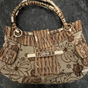 Guess väska - Fin guess väska🩷 Som man kan se på bilderna så har ”färgen” gått av på handtagen och det är en fläck inne i väskan. skicka gärna prisförslag 