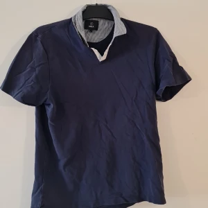 Pikétröja - Mörkblå piketröja, använt skick. Storlek: M Märke: Bläck