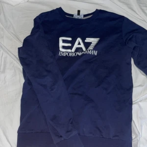 Ea7 hoodie  12 år - Armani hoodie för barn i 11-12 åldern. Använd ett fåtal gånger innan den blev för liten. Legat i en kartong i 3 år och den är en gammal modell. Klassisk mörkblå färg och skönt material med bra pris 👍