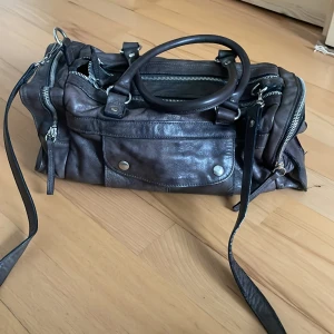 vintage väska köpt secondhand - Längd: 36 cm Höjd: 18 cm  Superfin vintage väska som är köpt secondhand. Har många fickor och fack så det finns mycket plats och håller mycket.💘 Det långa bandet kan man dessutom ta bort. ÄNVÄND INTE KÖP NU