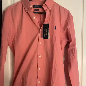 (säljer åt min kille då den inte passade honom) Korall/ljusrosa skitsnygg ralph lauren skjorta som är helt ny med lappar kvar, säljer eftersom den inte passade. Inget kvitto då den är beställd på zalando. Väldigt liten i strl så passar nog M-S