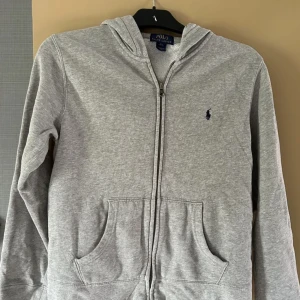 Grå ralph lauren zip up  - Grå ralph lauren zipup storlek 14-16 men sitter litet så skulle söga. Att sen sitter som ca 13