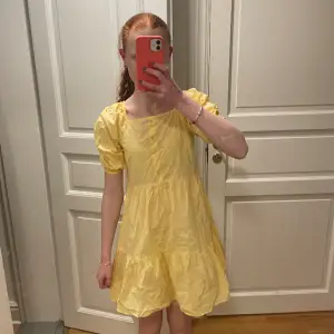 En gul klänning från Lindex barn, storlek 140 men känns mera som en 158/164