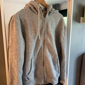Grå hoodie från Superdry XS - Mysig grå hoodie från Superdry i storlek XS. Tröjan har dragkedja, huva med snörning och två fickor framtill. Perfekt för chill dagar och enkel att matcha med jeans eller mjukisbyxor.
