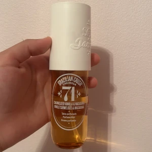 Sol de Janeiro 71 - Säljer en Sol de Janeiro Brazilian Crush Cheirosa 71 parfymmist med doft av karamelliserad vanilj och macadamia. Flaskan är genomskinlig med gyllene vätska och har ett stort vitt lock med präglad logga. Perfekt för dig som älskar söta, varma dofter.