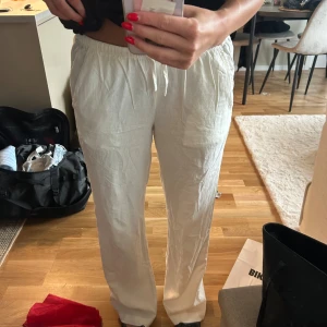 Vita linnebyxor med resårmidja - Säljer ett par fräscha vita linnebyxor med avslappnad passform och resår i midjan. Byxorna har raka ben och är perfekta för varma dagar. Lätta och luftiga, passar dig som gillar en chill och stilren look. Storlek S - regular (jag är 170cm) - aldrig använda men lappen är inte kvar, nypris 500