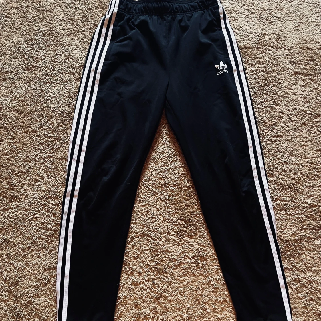 Svarta Adidas byxor med vita ränder