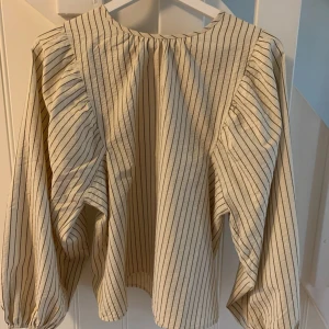 Randig blus från Carin Wester - Säljer en snygg randig blus från Carin Wester i beige med svarta tunna ränder. Storlek 40 men passar mig som använder XS/S i toppar💗