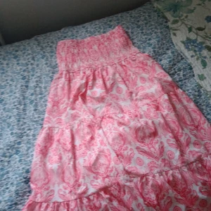 Rosa och vit kjol med mönster från shein - Supersöt klänning i rosa och vitt med ett unikt mönster. Den har smock upptill och ett flowy fall som ger en avslappnad vibe. Perfekt för varma dagar när du vill känna dig både bekväm och snygg.