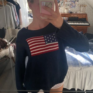Stickad tröja med flagga - Sydd i armen pga skada.