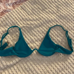 Turkos bikiniöverdel med bygel - Snygg turkos bikiniöverdel med bygel och justerbara axelband. I kameran ser den blå ut men den är mörkgrön-mintgrön i verkligheten. Triangelmodell och i storlek xs🩷
