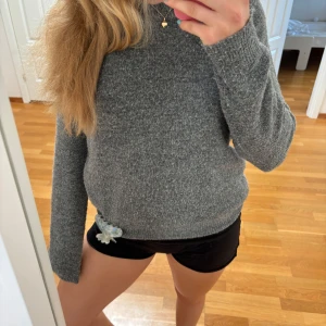Grå stickad tröja från H&M - Mysig grå stickad tröja från H&M i storlek S. Tröjan har en klassisk rund halsringning och långa ärmar. Perfekt för lager-på-lager och chill dagar. Materialet är mjukt och ger en avslappnad vibe. Tröjan är lite nopprig men fortfarande fin.