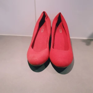 Rosa pumps från Din Sko, storlek 37 - Snygga rosa pumps från Din Sko i textilmaterial. Skorna har rund tå och en smal klack med låg höjd. Perfekta för dig som vill sticka ut med färg och ändå ha en klassisk siluett. Enkla att matcha med både jeans och klänning.  Klack=7cm Endast använda inomhus men dock finns obehandlad små fläckar