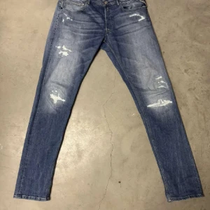 Replay jeans med slitningar  - Snygga blå jeans från replay i slim fit-modell med slitna detaljer och ljus tvätt. Klassisk femficksdesign och normal midja. Perfekta för dig som gillar en avslappnad men trendig look. Inga defekter, storlek 33/34 