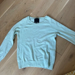 Ljusgrön stickad tröja Second Female - Supermjuk ljusgrön stickad tröja från Second Female i storlek S. Klassisk rund halsringning och långa ärmar, perfekt för lager-på-lager. Enkel och stilren design som funkar till allt. Materialet känns lätt och skönt mot huden.