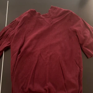 Vinröd stickad tröja med halvlång ärm - Vinröd stickad tröja med ribbad rund halsringning och halvlånga ärmar. Enkel och stilren design som passar perfekt till jeans eller kjol. Mjuk och skön känsla, perfekt för lager-på-lager under hösten eller vintern.