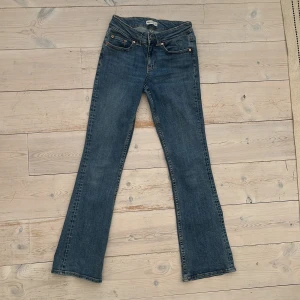 Blå bootcut jeans från Perfect Jeans Ginatricot - Snygga blå jeans från Perfect Jeans i klassisk bootcut-modell. Jeansen har fem fickor, knapp- och dragkedjegylf samt dekorativa bakfickor med lock och knapp. 