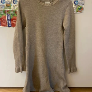 Beige stickad klänning från Vila XS - Mysig beige stickad klänning från Vila i storlek XS. Klänningen har lång ärm med lätt utsvängda muddar och rund halsringning. Perfekt för lager-på-lager och chill dagar. Enkel och stilren design som är lätt att matcha.