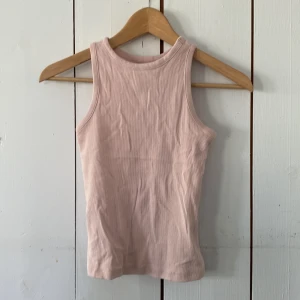 Ljusrosa ribbad linnetopp Esmara XS - Supersöt ljusrosa ribbad linnetopp från Esmara. Modellen är ärmlös med klassisk rund halsringning och tight passform. Perfekt att styla med jeans eller kjol för en chill look.