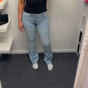 Ljusblå bootcut jeans - Säljer ett par ljusblå jeans med bootcut-modell. Byxorna har klassisk femficksdesign, medelhög midja och är tillverkade i mjukt denimtyg. Perfekta för dig som gillar en retro vibe och vill ha ett par jeans som sitter snyggt över höfterna och släpper ut vid benen. I storlek 170 men sitter som en xs/s