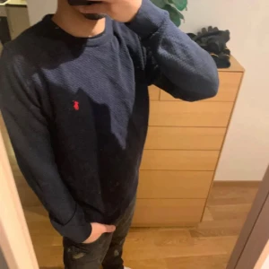 Mörkblå stickad tröja från Polo Ralph Lauren - Snygg mörkblå stickad tröja från Polo Ralph Lauren med klassisk rund halsringning och röd broderad logga på bröstet. NYPRIS:2299Kr MITT PRIS: 329Kr☄️