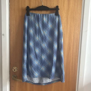 Blårutig långkjol från KappAhl - Snygg långkjol från Number One by KappAhl i blått med rutigt mönster i ljusblått och vitt. Kjolen har rak passform och är tillverkad i ett lätt och mjukt material, perfekt för en chill och stilren look💗💗