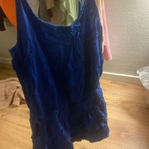 Blå ärmlös kortklänning - Snygg blå kortklänning med ärmlös design och rundad halsringning. Perfekt för varma dagar och enkel att styla med accessoarer. Klänningen har en ledig passform och är tillverkad i ett lätt material som känns skönt mot huden.