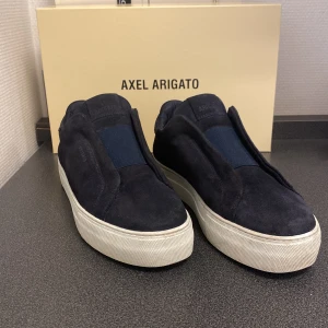 Mörkblå mocka, Axel Arigato - Tjena, säljer mina Axel Arigato då de har blivit för små. Skorna har används få gånger och är i mycket bra skick. Mockan är i bra kvalitet, även sulan. Arigato boxen hänger även med.