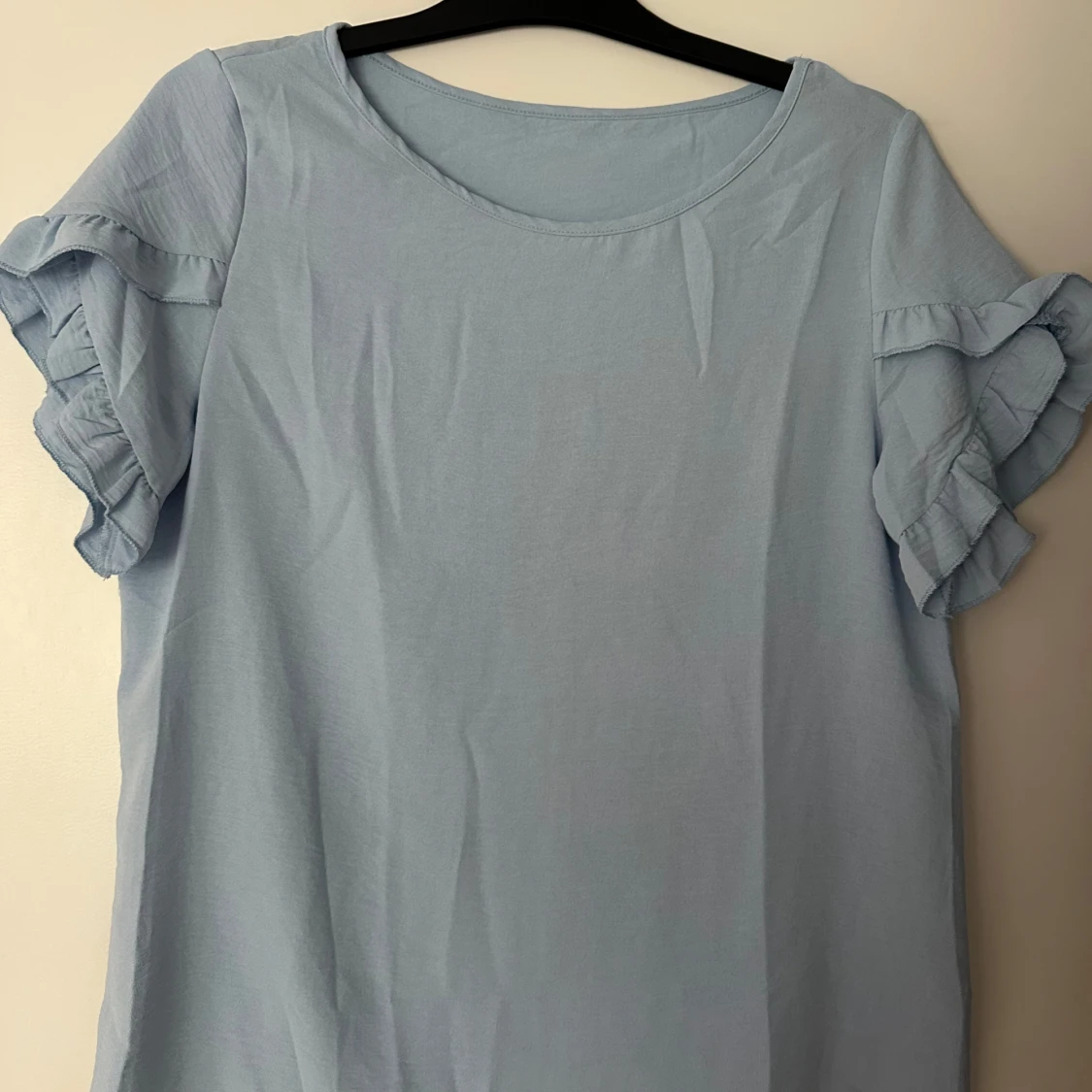 Ljusblå blus med volangärmar