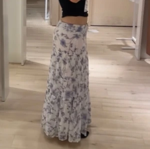 Vit långkjol med blå blommor - Superfin långkjol i vitt med blått blommönster. Använd 2-3 gånger och är i bra skick.