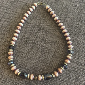 Unikt tungt halsband i glas - vintagekänsla - Ett vackert och gediget halsband med glaspärlor i lila och vit marmorerad ton, kombinerat med slipade, fasetterade pärlor som fångar ljuset som kristall. Mellan pärlorna sitter infattade spacers med glittrande stenar för extra elegans.  Halsbandet är tungt och kallt vid beröring, vilket tydligt visar att det är gjort i glas, inte plast – ett smycke med riktig tyngd och närvaro. Perfekt för dig som gillar vintagekänsla, statement pieces eller unika smycken med hantverkskänsla.