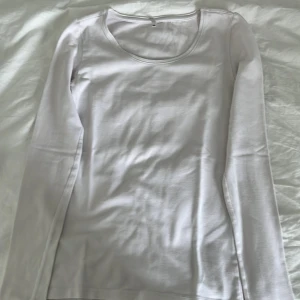 Vit långärmad tröja från ONLY - En basic vit långärmad tröja från ONLY i storlek XS. Tröjan har rund halsringning och är gjord i mjuk bomull, perfekt att styla med jeans eller kjol. Enkel och clean look som funkar året runt.