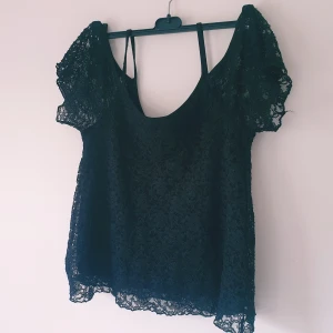 Svart spetsblus från Gina Tricot strl S - Svart blus från Gina Tricot i storlek S, helt i genombruten spets med korta ärmar och rundad halsringning. Luftig och lätt, perfekt att styla med jeans eller kjol för en cool look. Spetsen ger en extra touch och gör toppen unik.  Helt skick dock noppror & små tråddragning (ej hål!)