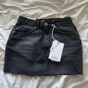 Svart jeanskjol från Pull&Bear - Svart lågmidjad jeanskjol från Pull&Bear. Ny med prislapp !!